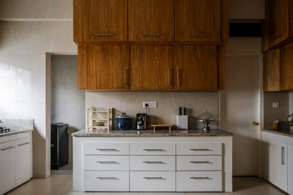 Teak upper cabinets over a white drawer base